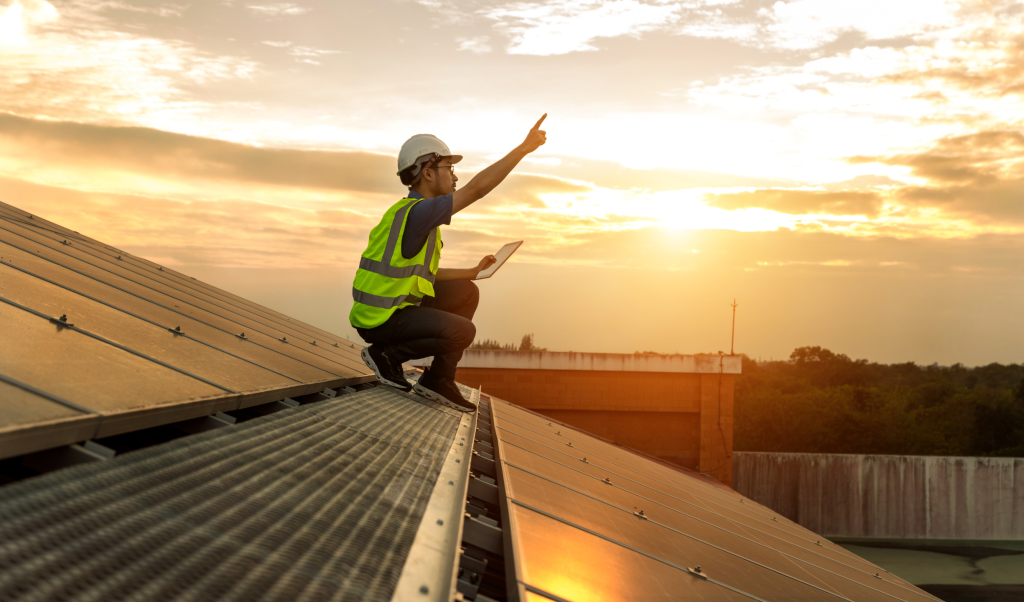 Man on top of roof, solar energy